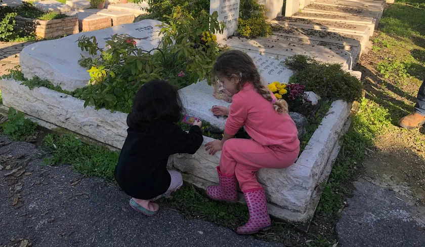 שתי בנות יושבות על קבר