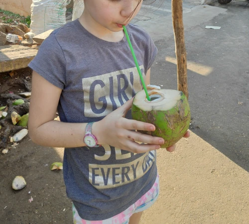 ילדה שותה קוקוס על קש
